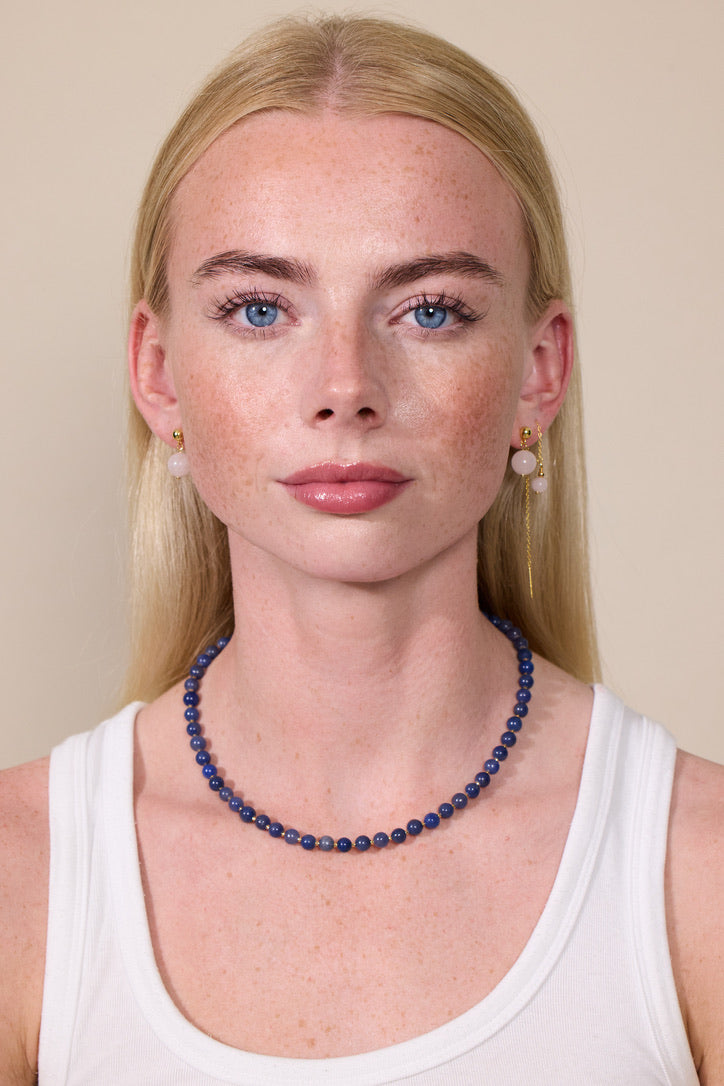 Frau trägt Perlenkette aus blauer Jade und Ohrringe aus rosa Jade