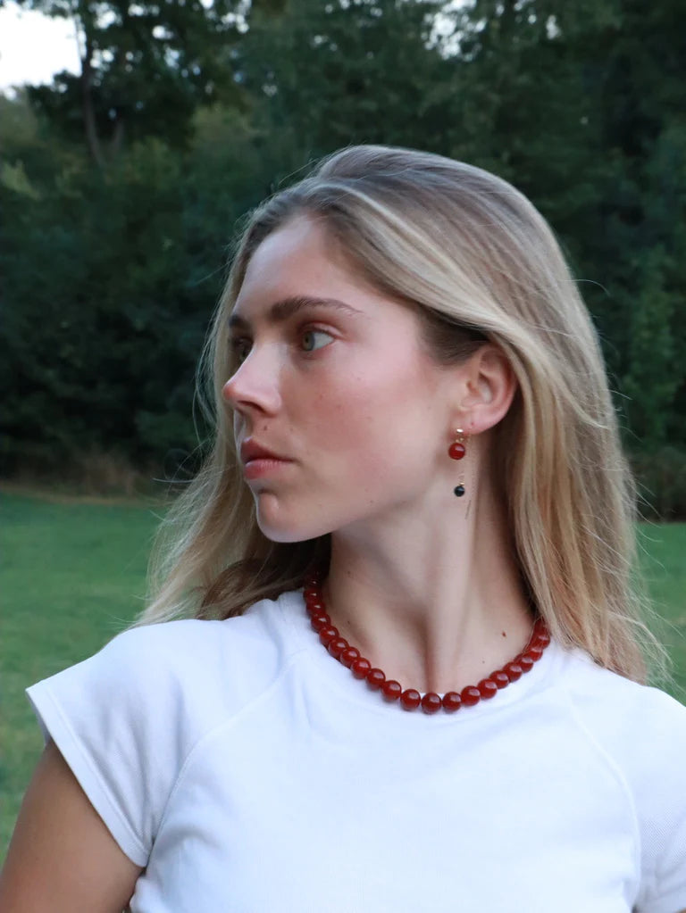 Frau trägt Kette und Ohrringe aus roter Jade von Soi