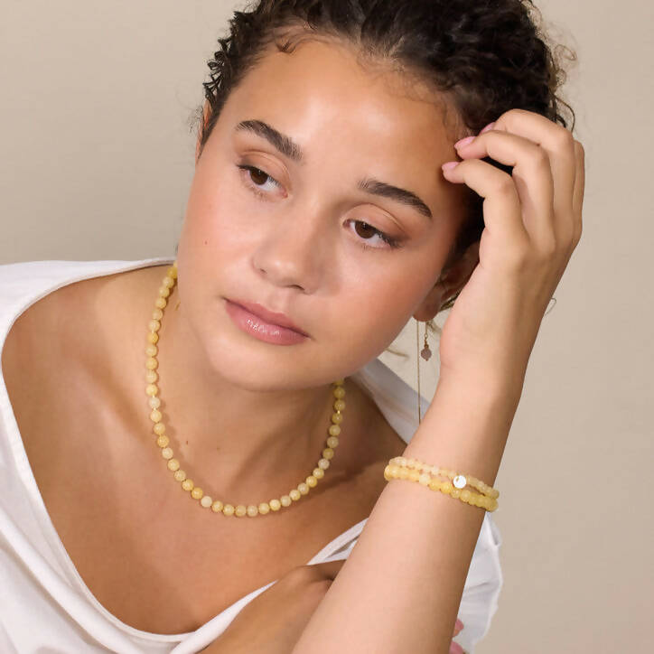 Frau trägt Kette und Armband aus gelber Jade