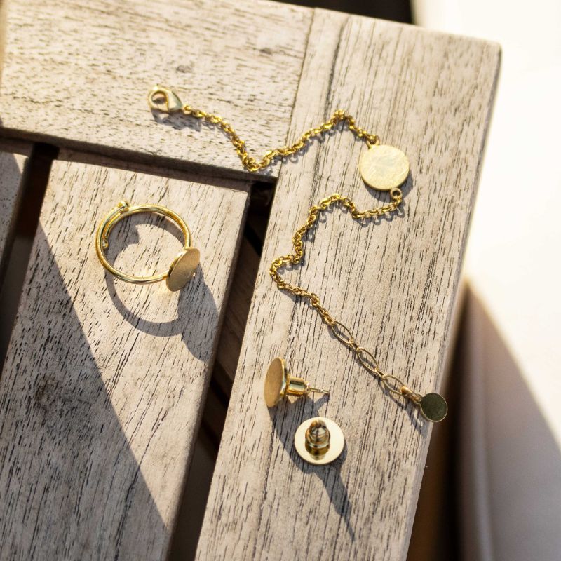 Edelstahl Schmuck vergoldet aus der Pura Kollektion auf einem Holztisch