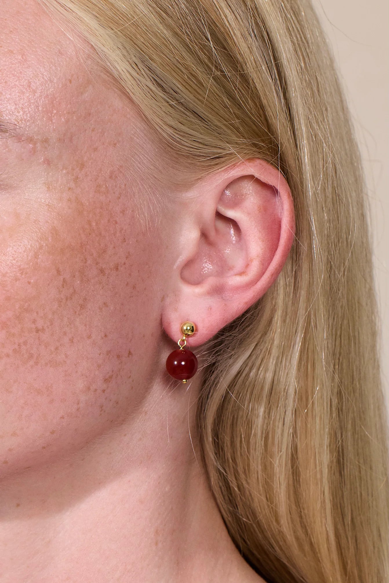 Frau trägt Ohrringe aus roter Jade