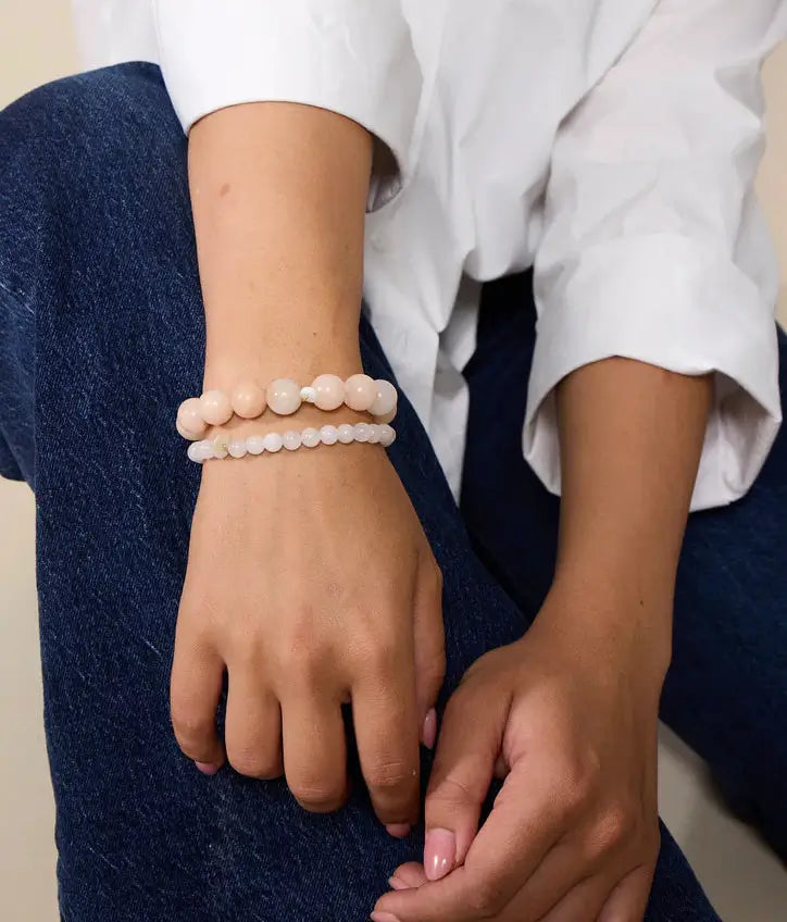 Perlenarmband aus rosa Jade und Mondstein am Handgelenk einer Frau